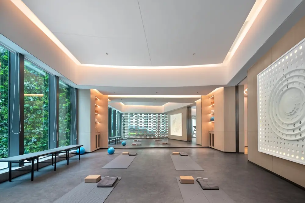 A wide studio with large windows and yoga mats