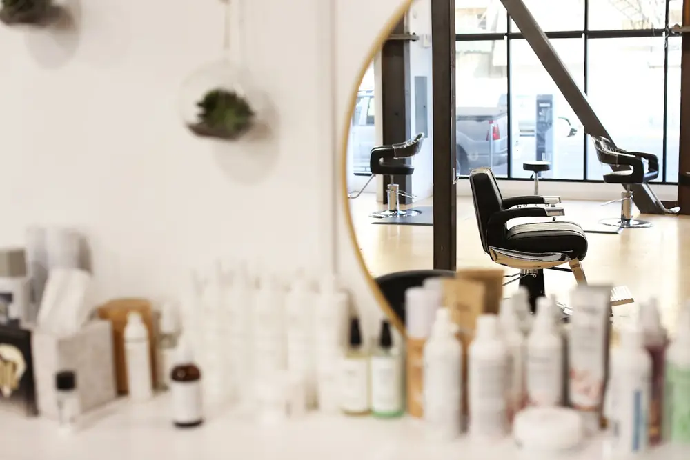 A salon styling station with mirrors and care products
